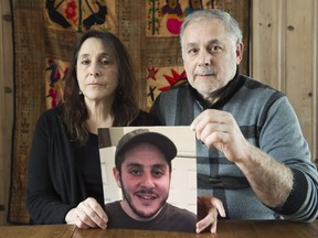 Jacob and Rachel Cohen hold up a photograph of their son Noam at their home in Montreal, Friday, February 9, 2018.