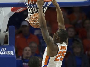 Florida forward Keith Stone (25) dunks over Alabama forward Daniel Giddens (4) during the first half of an NCAA college basketball game in Gainesville, Fla., Saturday, Feb. 3, 2018.