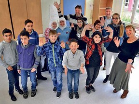 This undated family photo shows Adeeb Ayoub, 13, center, who had fled Syria with his uncle in 2015 to Germany, posing for a picture with other refugees children and their German teachers at a school for refugees in Germany. A small but growing number of refugees are returning to Syria, including some who made a dangerous sea journey to Europe to flee the war. Unable to stand the cold weather, language barrier, unemployment and depression, they have chosen to return to their war-torn country rather than stay in Europe. (Ayoub Family photo via AP)