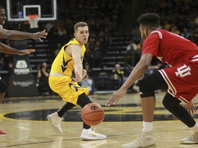 Iowa's Jordan Bohannon passes to Tyler Cook, not pictured, during an NCAA college basketball game against Indiana, Saturday, Feb. 17, 2018 in Iowa City, Iowa.