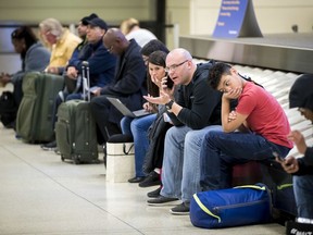 Stranded passengers endure a wait for checked baggage at Chicago Midway International Airport in Chicago after a winter storm moving across the Great Lakes has forced the cancellation of hundreds of flights Sunday, Feb. 11, 2018.