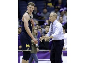 Michigan coach John Beilein, right, talks to forward Moritz Wagner during the first half of the team's NCAA college basketball game against Northwestern, Tuesday, Feb. 6, 2018, in Rosemont, Ill.