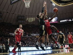 Ohio State forward Jae'Sean Tate, right, tries to shoot around Purdue defenders Vincent Edwards, left, and Matt Haarms during the first half of an NCAA college basketball game in West Lafayette, Ind., Wednesday, Feb. 7, 2018.