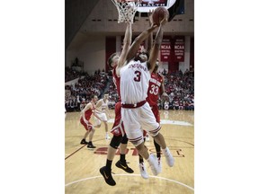 Indiana forward Justin Smith, center, goes to the basket in front of Ohio State center Micah Potter, left, and forward Keita Bates-Diop during the first half of an NCAA college basketball game in Bloomington, Ind., Friday, Feb. 23, 2018.
