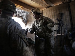 In this Friday, Jan. 26, 2018 photo, U.S. Army Sgt. Kaylin Jones, 25, stands at a guard tower on the perimeter of a small coalition outpost on the western edge of Iraq. A few hundred American troops are stationed at a small outpost near the town of Qaim along Iraq's border with Syria. Thousands of U.S. troops and billions of dollars spent by Washington helped bring down the Islamic State group in Iraq, but many of the divisions and problems that helped fuel the extremists' rise remain.
