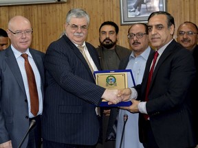 In this Feb. 19, 2018 photo, Zahid Ullah Shinwari, right, President Sarah Chamber of Commerce and Industry presents souvenir to Russian ambassador Alexey Yurievich Dedov in Peshawar, Pakistan. As Pakistan navigates its troubled relationship with the United States and scrambles to avoid being blacklisted for doing too little, too late to stop terrorist funding, regional alliances are shifting and analysts ponder whether a cozier relationship with countries, like Russia, will complicate efforts to plot a path to peace in Afghanistan and civility between uneasy neighbors.