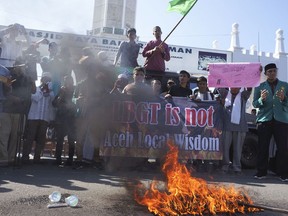 Muslim protesters pray as they burn an effigy during an anti-LGBT rally in Banda Aceh, Indonesia, Friday, Feb. 2, 2018. Several hundreds of people staged the rally to protest against an investigation into local police who rounded up and publicly humiliated transgender women.