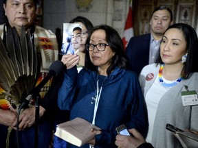 Debbie Baptiste, mother of Colten Boushie, holds up a photo of her son as she speaks to reporters in the Foyer of the House of Commons after a day of meetings on Parliament Hill, in Ottawa on Tuesday, Feb. 13, 2018.