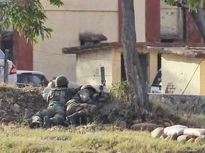 An Indian soldiers take position as they surround the residential quarters where militants are believed to be holed up in an Army camp in Jammu, India, Sunday, Feb. 11, 2018. At least two soldiers were killed and three others wounded in Indian-controlled Kashmir on Saturday as soldiers traded fire with armed militants who were holed up inside an army camp, officials said.