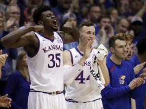 Kansas center Udoka Azubuike (35) and Kansas forward Mitch Lightfoot (44) celebrate a basket from the bench during the second half of an NCAA college basketball game against Oklahoma in Lawrence, Kan., Monday, Feb. 19, 2018. Kansas defeated Oklahoma 104-74.