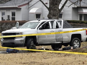EDS NOTE: GRAPHIC CONTENT- A body lies next to a vehicle following a deadly shooting in which a police officer was injured on Thursday, Feb. 1, 2018, in Louisville, Ky. Louisville Metro Council President David James, a former police officer, said Thursday that he was told by officers that the wounded officer is expected to be OK. He had no details about the circumstances. Louisville police did not immediately release a statement.