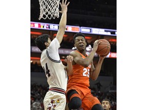 Syracuse guard Tyus Battle (25) goes up to shoot past the defense of Louisville forward Anas Mahmoud (14) during the first half of an NCAA college basketball game, Monday, Feb. 5, 2018, in Louisville, Ky.
