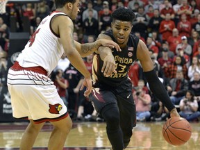 Florida State guard M.J. Walker (23) attempts to drive past the defense of Louisville guard Quentin Snider (4) during the first half of an NCAA college basketball game, Saturday, Feb. 3, 2018, in Louisville, Ky.