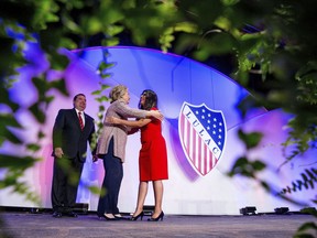 FILE - In this July 14, 2016 photo Democratic presidential candidate Hillary Clinton, accompanied by LULAC President Roger C. Rocha, Jr., left, hugs University of Texas student Dreamer Lizeth Urdiales, right, as she arrives to speaks at the 87th League of United Latin American Citizens National Convention at the Washington Hilton in Washington. Rocha, Jr. the president of the oldest Latino civil rights organization in the U.S. is facing harsh criticism for endorsing President Donald Trump's immigration framework that includes a border wall.