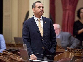 FILE - In this Jan. 3, 2018 file photo, state Sen. Tony Mendoza, D-Artesia, stands at his desk after announcing that he will take a month-long leave of absence while an investigation into sexual misconduct allegations against him are completed, during the opening day of the Senate in Sacramento, Calif. Mendoza announced Thursday, Feb. 22, 2018 that he is resigning over sexual misconduct allegations just ahead of a possible vote by his colleagues to expel him. In his resignation letter, Mendoza called the Senate's process "farcical" and unfair and is still considering running for re-election in the fall.