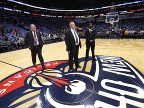 New Orleans Pelicans president Dennis Lauscha, left, walks on the court during a delay for the start of an NBA basketball game against the Indiana Pacers in New Orleans, Wednesday, Feb. 7, 2018. The game was under a delay due to moisture on the court falling from the rafters.