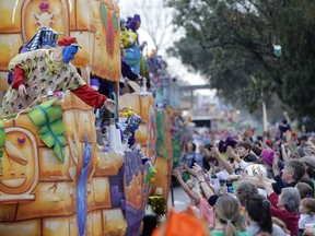 Float riders toss beads and trinkets during the Krewe of Thoth Mardi Gras parade in New Orleans, Sunday, Feb. 11, 2018. The krewe's original parade route was designed specifically to serve people who were unable to attend other parades in the city. The route passes in front of several extended healthcare facilities. Carnival season will culminate on Mardi Gras day this Tuesday, Feb. 13.