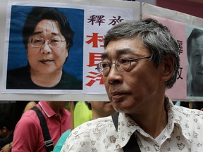 Hong Kong bookseller Lam Wing-kee, who was detained and then released by China, stands next to a photo of bookseller Gui Minhai, a Swedish citizen imprisoned by Beijing, in a file photo from June 18, 2016.
