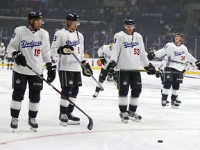 Los Angeles Kings center Alex Iafallo (19), left winger Adrian Kempe (9), defenseman Kevin Gravel (53) and defenseman Paul LaDue (38) wear Los Angeles Dodgers jerseys for Dodger Night during warmups for the team's NHL hockey game against the Arizona Coyotes in Los Angeles on Saturday, Feb. 3, 2018. The jerseys are to be auctioned for charity.
