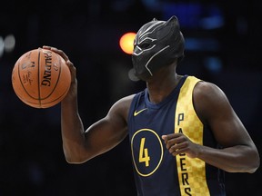 Indiana Pacers' Victor Oladipo gets ready for a dunk while wearing a mask from the movie "Black Panther" during the NBA All-Star basketball slam dunk contest Saturday, Feb. 17, 2018, in Los Angeles.