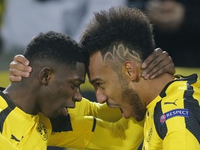 FILE - In this March 8, 2017 file photo Dortmund's Ousmane Dembele, left, congratulates Dortmund's Pierre-Emerick Aubameyang as they celebrate after scoring the opening goal during the Champions League round of 16, second leg, soccer match between Borussia Dortmund and Benfica in Dortmund, Germany. The big-money moves of Dembele and now Aubameyang underline a crisis of identification at Borussia Dortmund. Both players forced their way out of the club after feeling the need to move onto bigger and better stages to showcase their talents.