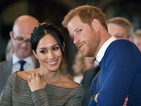 FILE - In this Thursday Jan. 18, 2018 file photo, Britain's Prince Harry talks to Meghan Markle as they watch a dance performance by Jukebox Collective in the banqueting hall during a visit to Cardiff Castle, Wales. With Prince Harry and Meghan Markle's May 19 wedding fast approaching, the fashion and bridal worlds are abuzz with talk of who the bride will pick to design her dress and what kind of look she would go for.