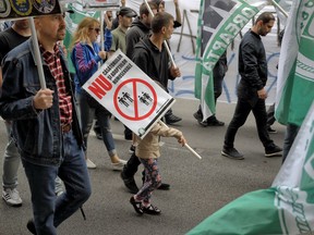 FILE - In this Saturday, May 20, 2017 file photo, a child holds a sign that reads "No to homosexual marriages and adoptions" during a counter march before of a gay pride parade in Bucharest, Romania. Religious protesters in Romania have disrupted the screening of two movies in Bucharest in Feb. 2018, saying they violate traditional values. The recent protests illustrate divided views about homosexuality, a provocative and difficult topic in the European Union member.