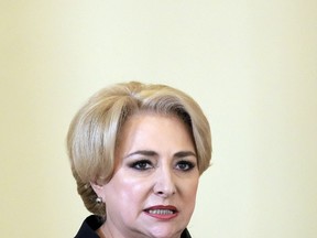 FILE - In this Monday, Jan. 29, 2018 file photo, Romanian Prime Minister Viorica Dancila reads the oath during the swearing in ceremony of her cabinet, in Bucharest, Romania. A government council cleared Romania's prime minister Monday Feb. 26, 2018 of wrongdoing for using the word "autistic" to describe political rivals.
