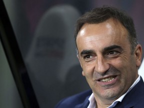 FILE - In this file photo dated Wednesday, Sept. 23, 2015, Sheffield Wednesday's manager Carlos Carvalhal awaits the start of the English League Cup third round soccer match between Newcastle United and Sheffield at St James' Park, Newcastle, England. Carvalhal seems to be giving new energy to revitalize Swansea and is fast becoming a new darling of British soccer with his colorful analogies, infectious enthusiasm and positive outlook.