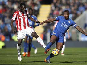 Leicester City's Wes Morgan, right, and Stoke City's Mame Biram Diouf vie for the ball during the English Premier League soccer match, Leicester City against Stoke City, at the King Power Stadium, Leicester, England, Saturday Feb. 24, 2018.