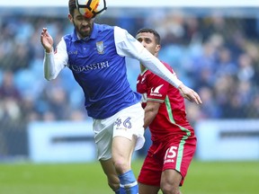 Sheffield Wednesday's Andre Frederico Venancio, left, and Swansea City's Wayne Routledge battle for the ball during the English FA Cup, Fifth Round match at Hillsborough, Sheffield. England. Saturday Feb. 17, 2018.