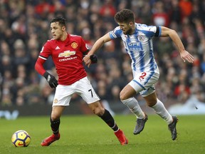 Manchester United's Alexis Sanchez, left, and Huddersfield Town's Tommy Smith, during their English Premier League soccer match at Old Trafford in Manchester, England, Saturday Feb. 3, 2018.