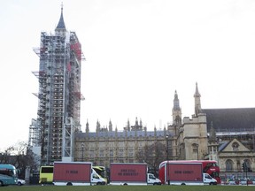 The Community-led organisation, Justice4Grenfell, parades three billboards past the Houses of Parliament in London Thursday Feb. 14, 2018, calling for justice for the victims of the June 14, 2017, deadly apartment fire.  Campaigners for victims of the deadly London Grenfell Tower high-rise apartment fire have taken inspiration from an Academy Award-nominated film to press for more action by police.