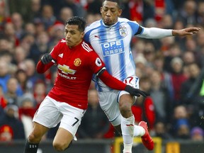 Manchester United's Alexis Sanchez, left, and Huddersfield Town's Rajiv van La Parra in action during their English Premier League soccer match at Old Trafford in Manchester, England, Saturday Feb. 3, 2018.