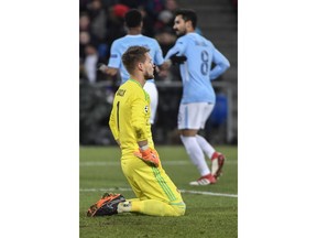 Basel's goalkeeper Tomas Vaclik, front, looks on as Manchester City's Raheem Sterling, left, and Ilkay Gundogan celebrate during the Champions League round of sixteen first leg soccer match between Switzerland's FC Basel 1893 and England's Manchester City FC in the St. Jakob-Park stadium in Basel, Switzerland, Tuesday, Feb. 13, 2018.