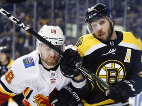 Calgary Flames' Matt Stajan (18) checks Boston Bruins' David Krejci (46), of the Czech Republic, during the first period of an NHL hockey game in Boston, Tuesday, Feb. 13, 2018.