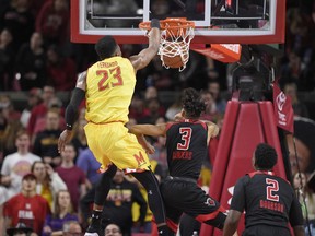 Maryland forward Bruno Fernando (23) dunks over Rutgers guard Corey Sanders (3) and center Shaquille Doorson (2) during the first half of an NCAA college basketball game Saturday, Feb. 17, 2018, in College Park, Md.