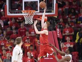 Maryland guard Kevin Huerter (4) goes to the basket against Wisconsin guard Khalil Iverson, bottom right, during the first half of an NCAA basketball game, Sunday, Feb. 4, 2018, in College Park, Md.
