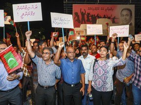 In this late Sunday, Feb.4, 2018 photo, Maldivian opposition supporters shout slogans during a protest as they the urge the government to obey a Supreme Court order to release and retry political prisoners, including an ex-president in Male, Maldives. The political crisis in the Maldives deepened Monday, as the government of the island nation said it would not obey a Supreme Court order to free a group of imprisoned opposition leaders. Placards in Divehi language from left, to right, read, "protect the citizens , carry out the supreme court's order, free political prisoners and to uphold justice".