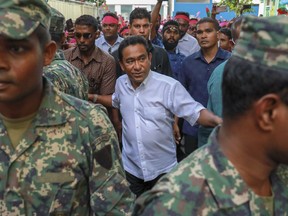 FILE- In this Feb. 3, 2018, file photo, Maldivian President Yameen Abdul Gayoom, center, surrounded by his body guards arrives to address his supporters in Male, Maldives. The president of the Maldives has asked Parliament to extend a state of emergency by two weeks as political turmoil continues in the country.