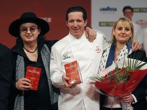 Three-star chefs Marc Veyrat of La Maison des Bois, left, Christophe Bacquie at the Castellet Hotel, center, and his wife Alexandra Bacquie pose during the Michelin Guide ceremony in Boulogne-Billancourt, outside Paris, France, Monday, Feb. 5, 2018. A record 28 French restaurants were honored with the gastronomic world's most coveted prize Monday: a three-star Michelin rating.