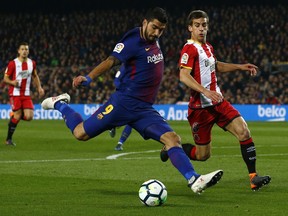 FC Barcelona's Luis Suarez, left, in action against Girona's Pere Pons during the Spanish La Liga soccer match between FC Barcelona and Girona at the Camp Nou stadium in Barcelona, Spain, Saturday, Feb. 24, 2018.
