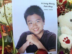 HOLD FOR AARON- Peter Wang is seen in this photo near a memorial in Parkland, Fla., Friday, Feb. 16, 2018. Wang, a student at Marjory Stoneman Douglas High School in Parkland, Fla., was killed when former student Nikolas Cruz opened fire at the school Wednesday, Feb. 14, 2018.