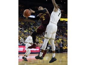 Minnesota guard Nate Mason (2) makes a layup as Michigan guard Charles Matthews (1) defends during the first half of an NCAA college basketball game, Saturday, Feb. 3,2018, in Ann Arbor, Mich.