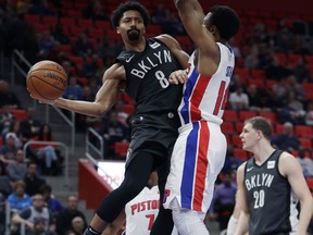 Brooklyn Nets guard Spencer Dinwiddie (8) passes the ball around Detroit Pistons guard Ish Smith (14) during the first half of an NBA basketball game Wednesday, Feb. 7, 2018, in Detroit.