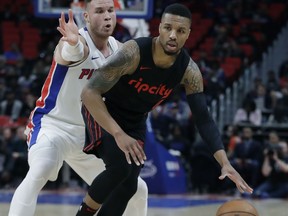 Detroit Pistons forward Blake Griffin, left, defends as Portland Trail Blazers guard Damian Lillard (0) dribbles during the first half of an NBA basketball game, Monday, Feb. 5, 2018, in Detroit.