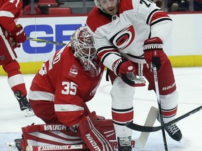 Carolina Hurricanes right wing Lee Stempniak (21) tries to get control of the puck in front of Detroit Red Wings goaltender Jimmy Howard (35) during the first period of an NHL hockey game Saturday, Feb. 24, 2018, in Detroit.