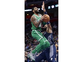 Boston Celtics guard Kyrie Irving (11) is defended by Detroit Pistons center Andre Drummond, right,while going to the basket during the first half of an NBA basketball game Friday, Feb. 23, 2018, in Detroit.