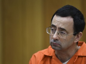 Larry Nassar listens as Rachael Denhollander gives her victim impact statement Friday, Feb. 2, 2018, in Eaton County Circuit Court, the second and final day of victim impact statements in Judge Janet Cunningham's courtroom in Charlotte, Mich. He will be sentenced Monday.