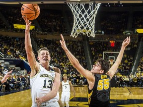 Michigan forward Moritz Wagner (13) attempts a basket, defended by Iowa forward Luka Garza (55) in the first half of an NCAA college basketball game at Crisler Center in Ann Arbor, Mich., Wednesday, Feb. 14, 2018.